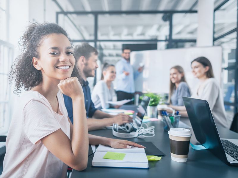 Teilnehmerinnen und Teilnehmer der Werbe Akademie sitzen an einem Tisch und folgen dem Vortrag des Trainers.